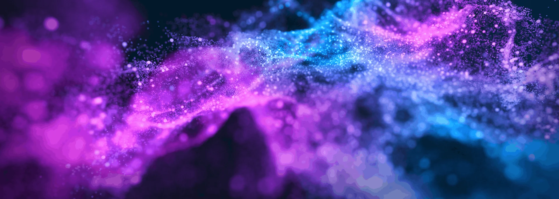 Violet and cyan particles forming an illuminated flowing wave